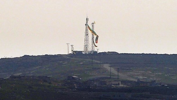Les combattants des forces du YPG ont symboliquement accroché un drapeau kurde tricolore de 75 mètres de long à un pylône sur une colline surplombant la ville détruite par quatre mois de combats.